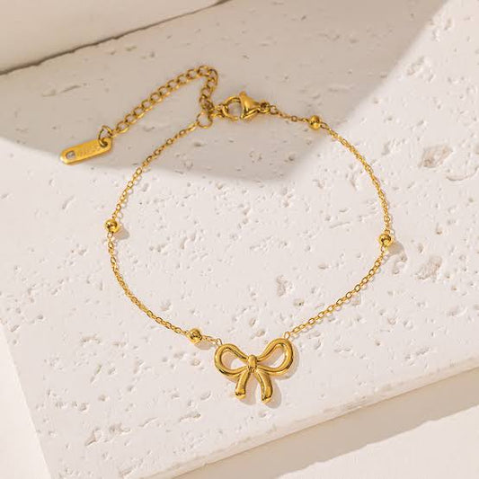 Anti-Tarnish Waterproof Bow Bracelet - Delicate Gold Chain with Ribbon Charm on a beige background.